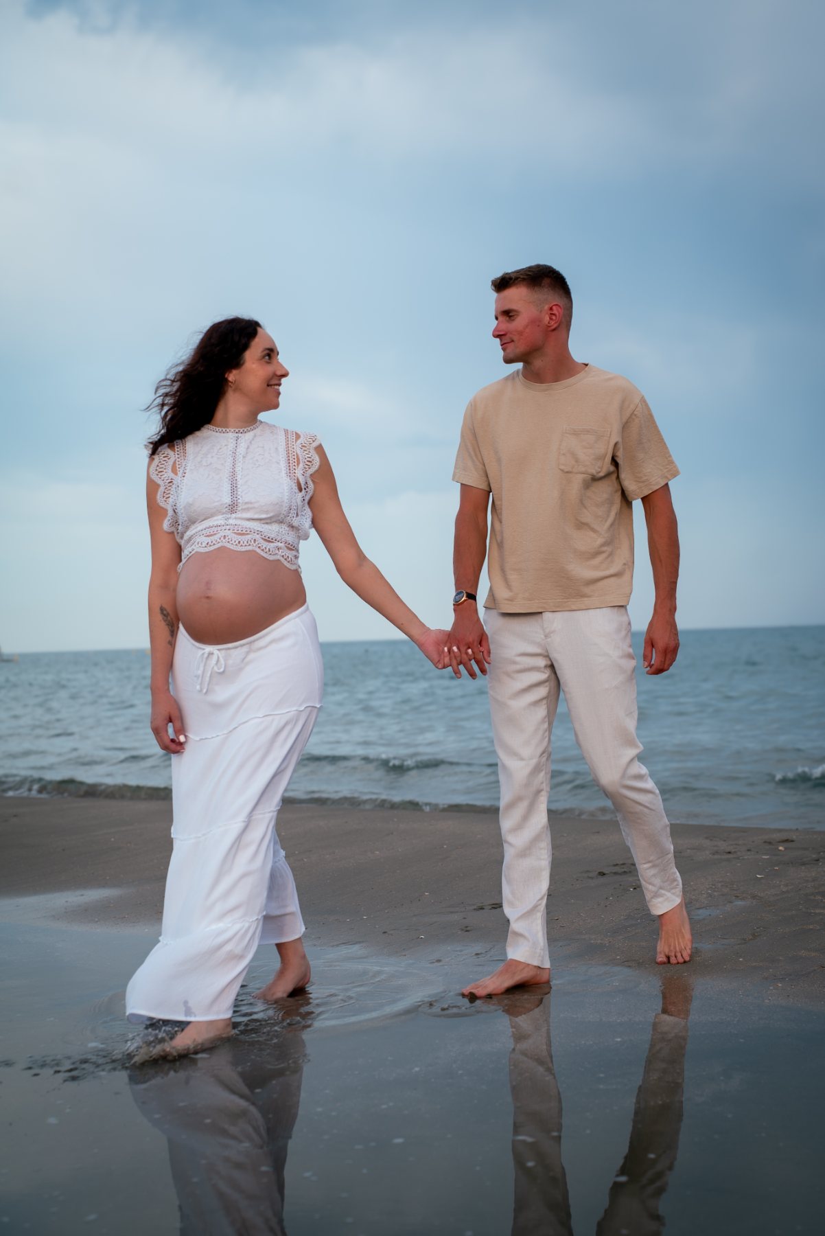 Couple qui marche main dans la main au bord de l'eau